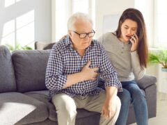 Senior man old father clutches chest in pain heart attack daughter calling to emergency. Daughter calling by phone to emergency senior father heart attack stressing cardiac problem heart attack