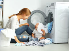 A baby and a mother in the laundry room