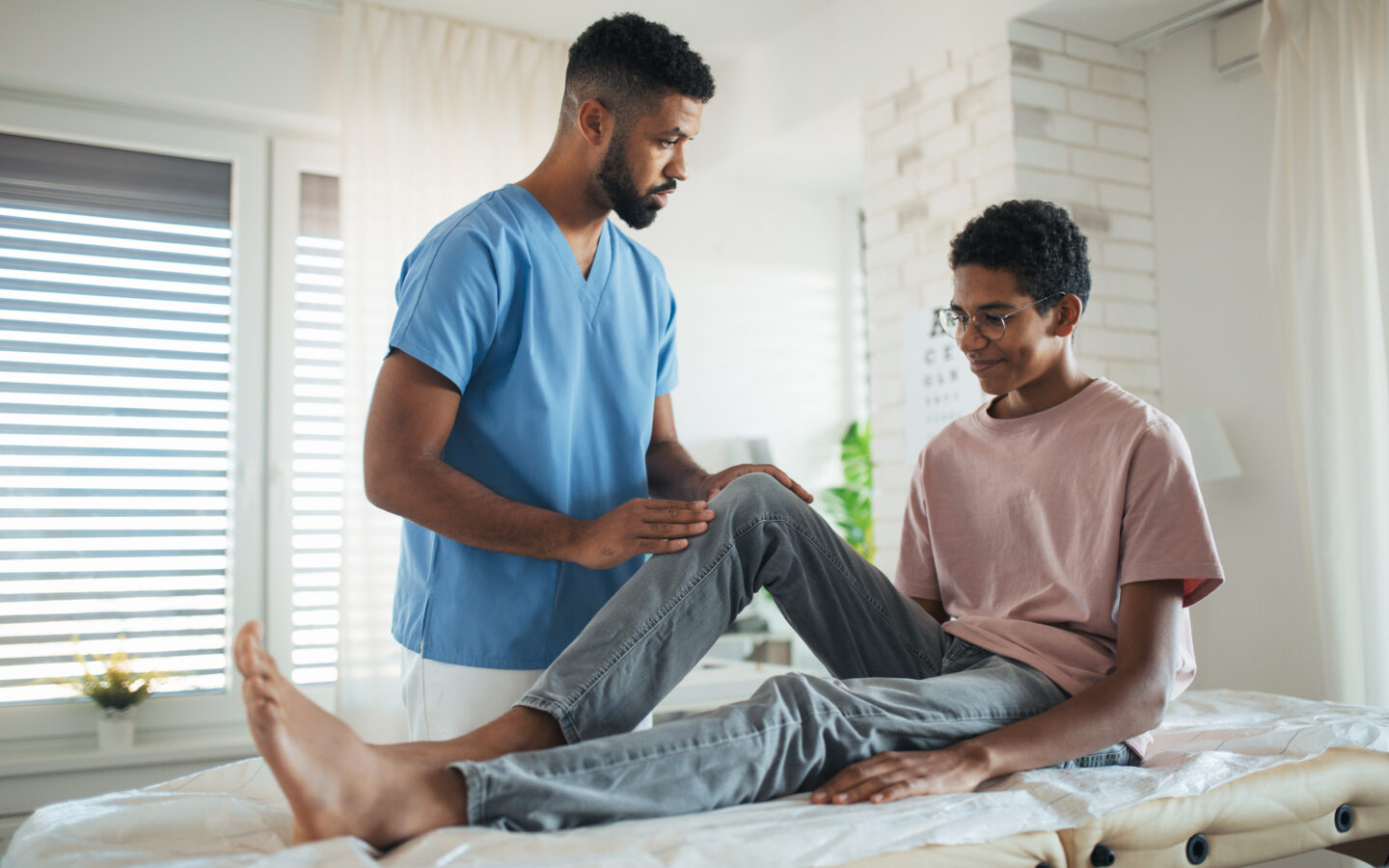 A physical therapist and a teenage patient.