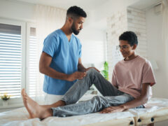 A physical therapist and a teenage patient.