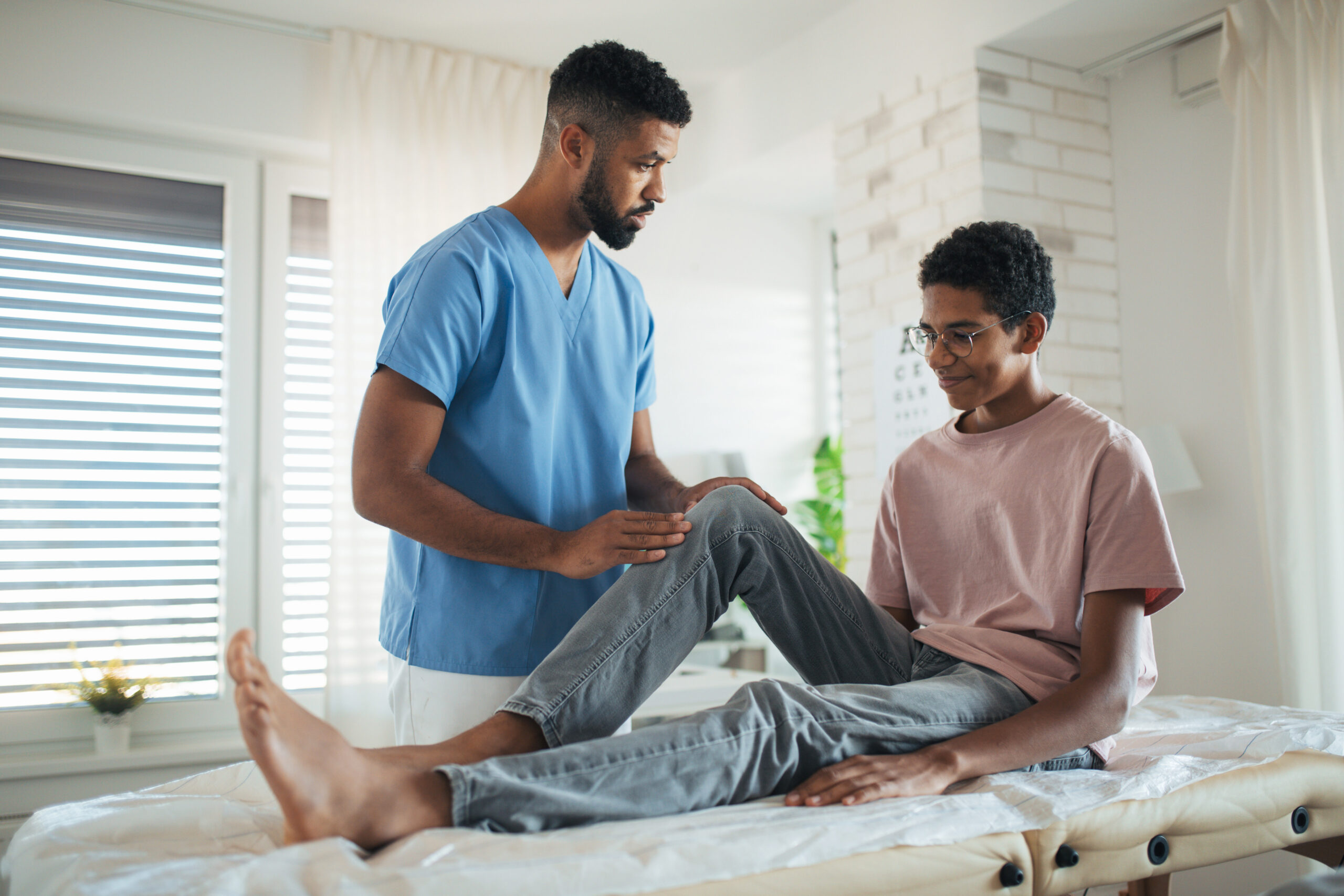 A physical therapist and a teenage patient.