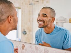 Man checking out his teeth in the mirror